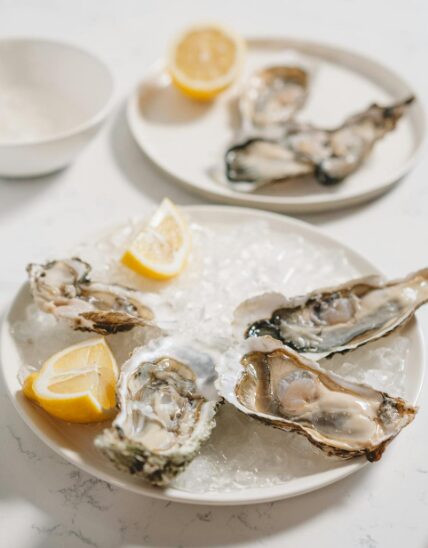 겨울철 제철 음식 신선한 굴과 상큼한 귤이 차려진 식탁 이미지