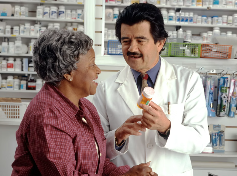 약국에서 약사에게 약에 대해서 상담을 받고있는 어르신 이미지