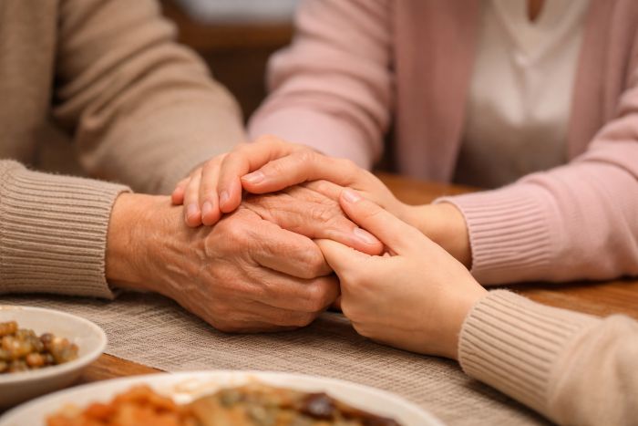 손떨림으로 위축된 부모님의 손을 따뜻하게 잡아주며 위로하는 자녀